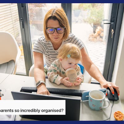 A woman works while her toddler sits on her lap drinking a bottle and watching a show on her mom's phone.