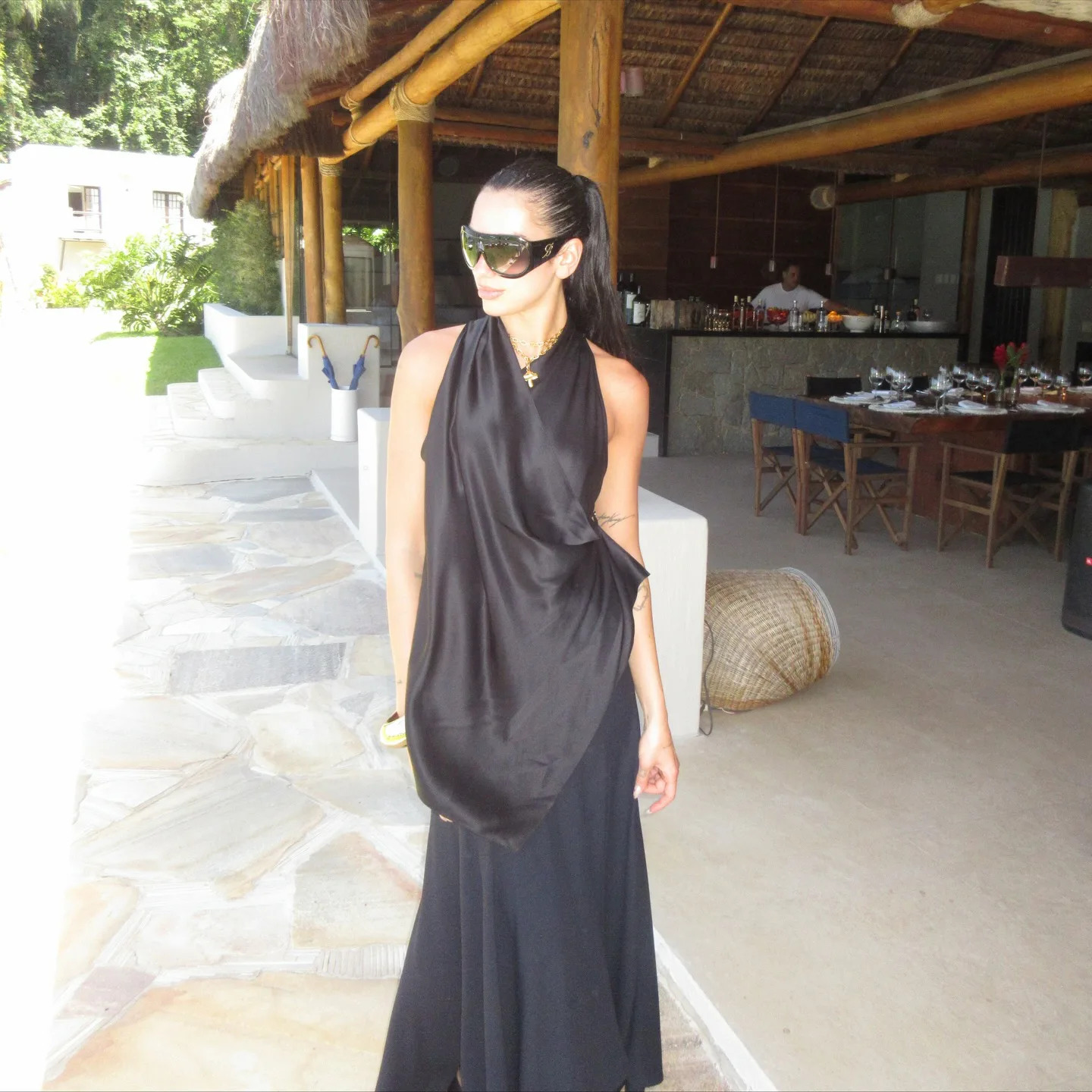 Dua Lipa wears a black dress. 