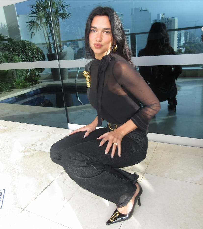 Dua Lipa wears a black outfit.