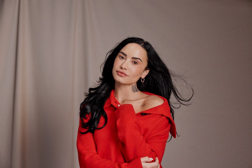 Demi Lovato wearing a red sweater from her Amazon Essentials collection.