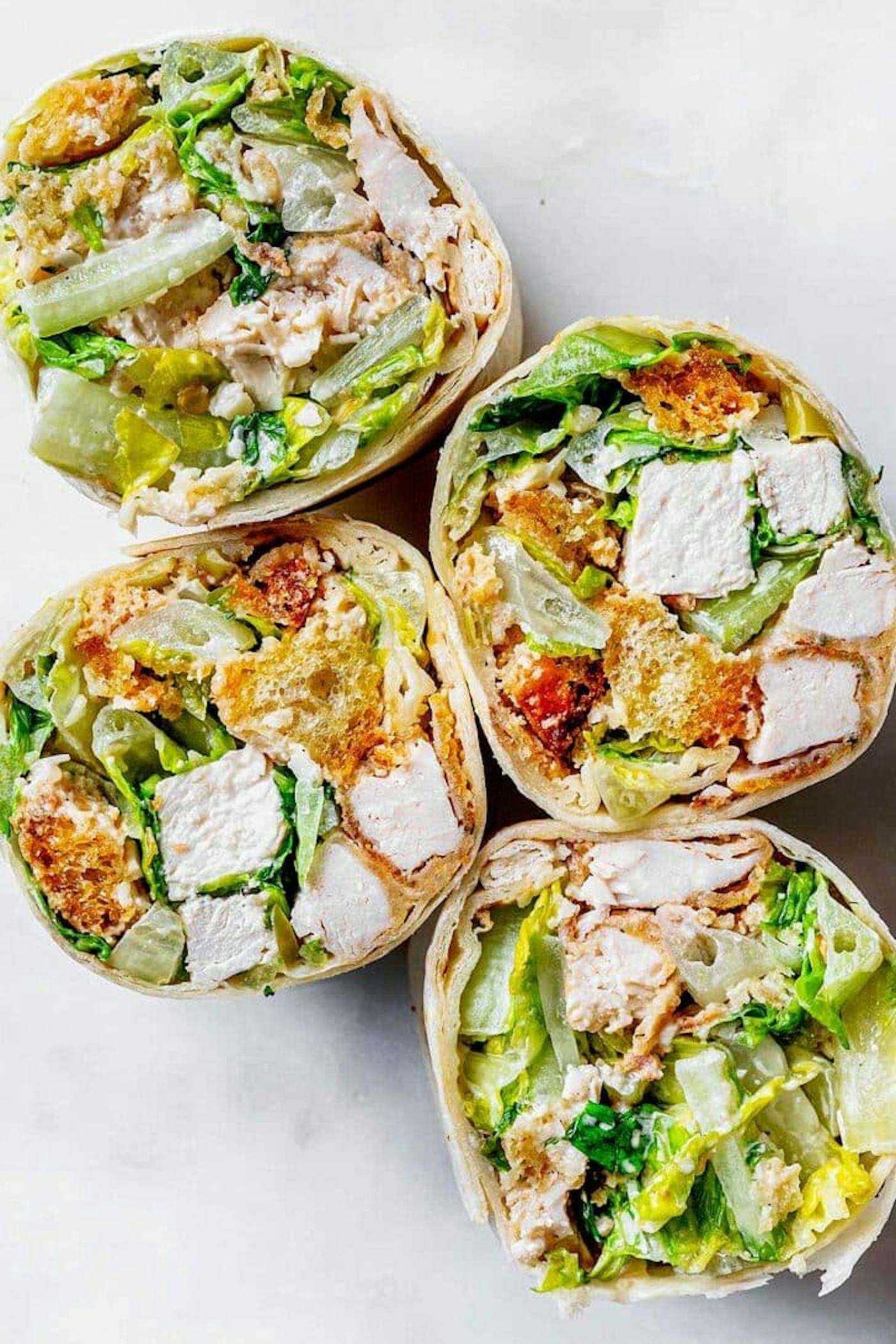 chicken caesar wrap cut in half, in a story about easy work lunch recipes