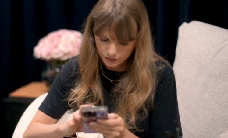 Taylor Swift is shown listening to Liz Moore's 'The God of the Woods' in her 'End of an Era' docuser...