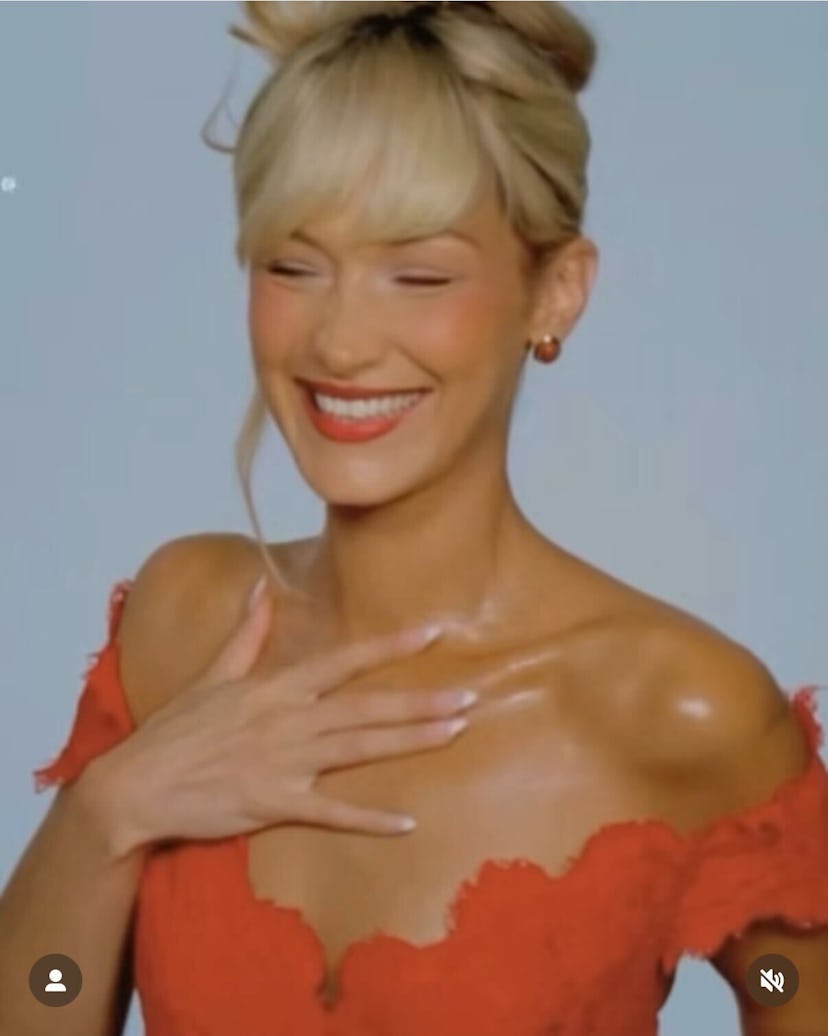Bella Hadid wears a red off-the-shoulder lace dress.