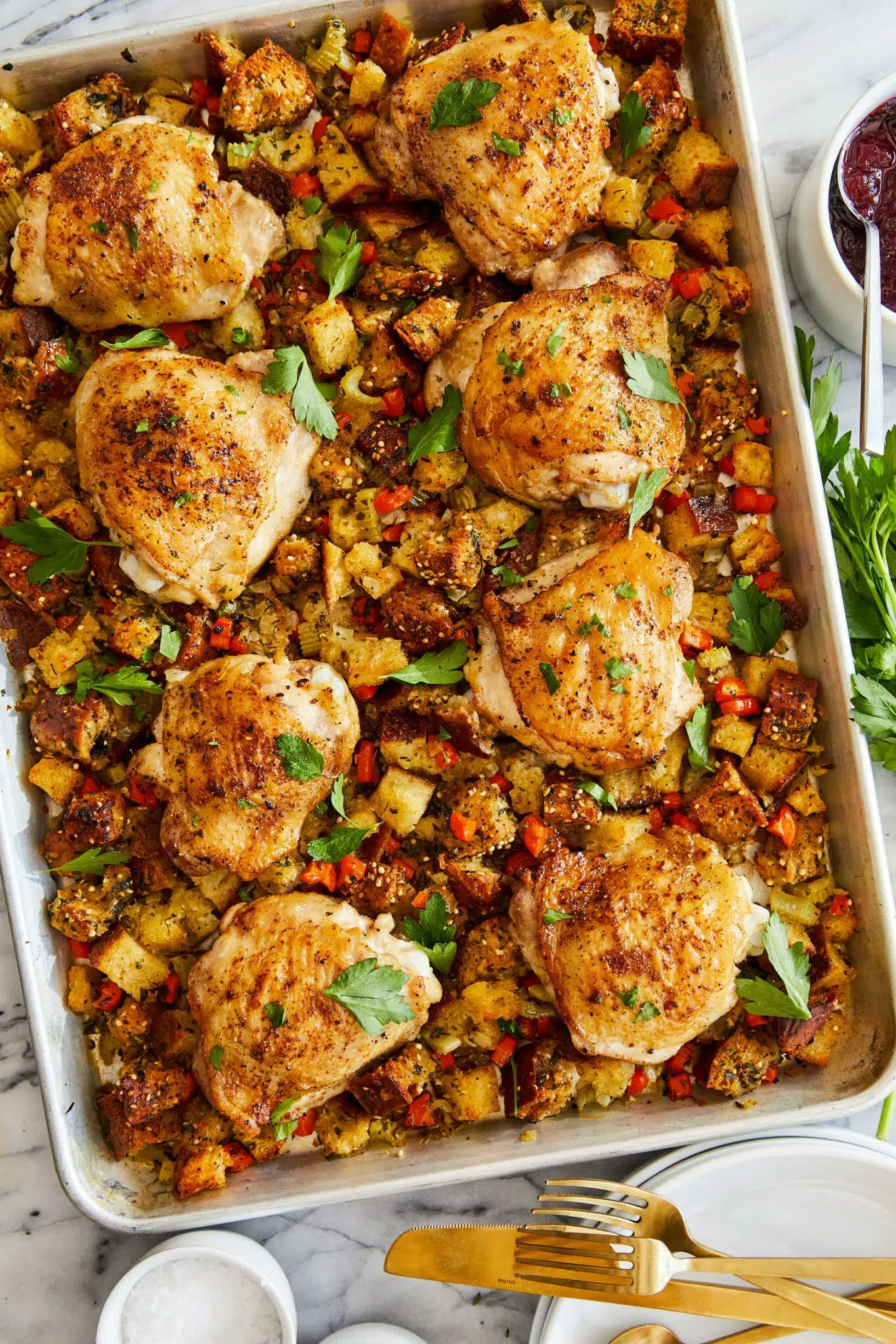 sheet pan with chicken thighs and stuffing, in a story about christmas recipes for a crowd