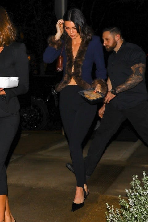 Hailey Bieber and Kendall Jenner wore '80's inspired looks with plunging necklines to a holiday part...