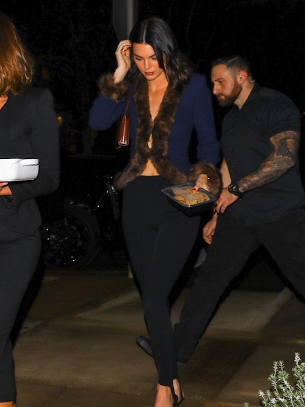 Hailey Bieber and Kendall Jenner wore '80's inspired looks with plunging necklines to a holiday part...