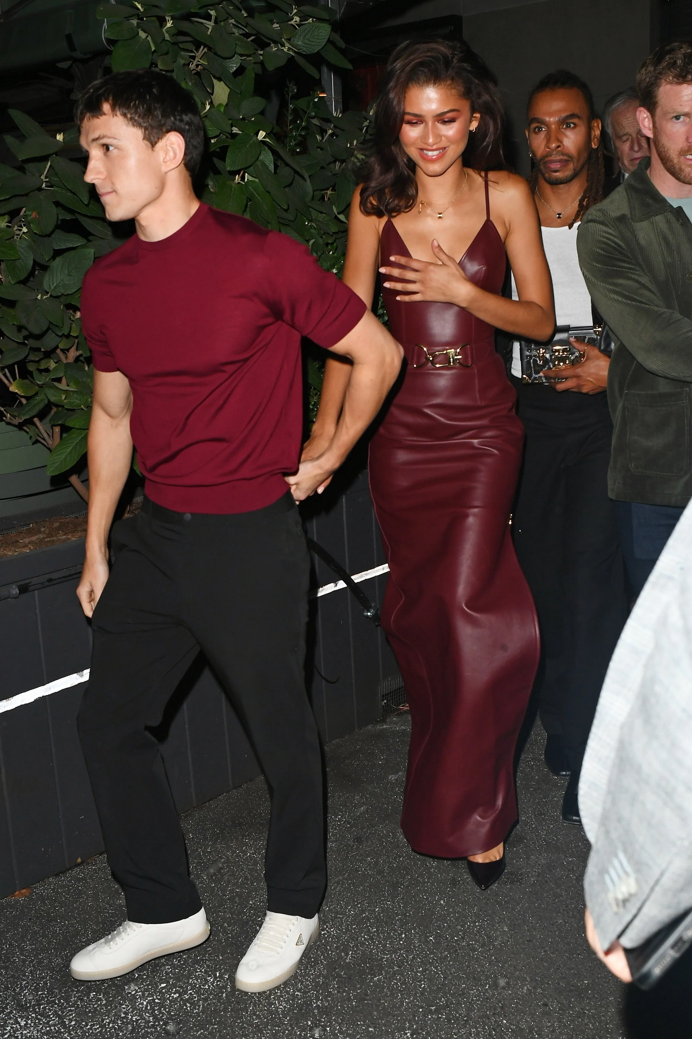 Tom Holland & Zendaya wearing matching burgundy outfits outside Corner Bar after Bero event in NYC.
