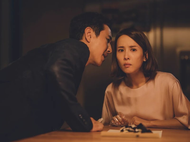 A man leans in toward a woman in a serious conversation, displaying concern. The woman looks puzzled...