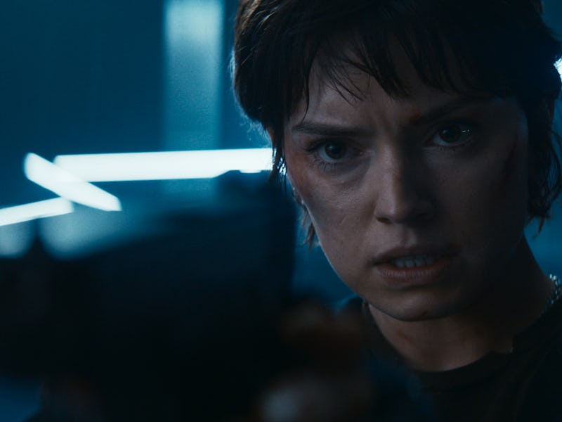 A close-up of a determined woman holding a gun, her intense expression illuminated by blue lighting ...