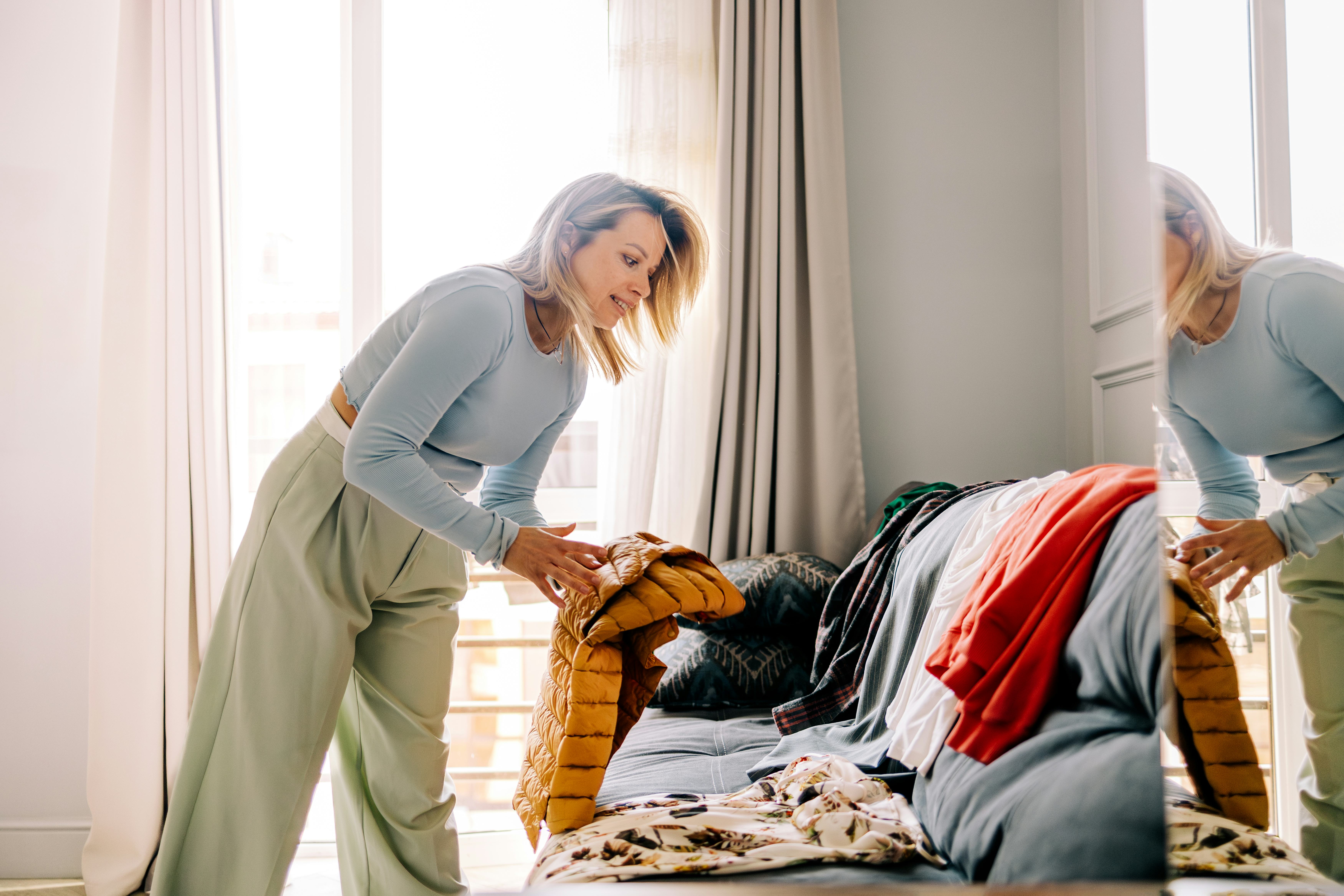 Millennial woman organizing her rental clothes.