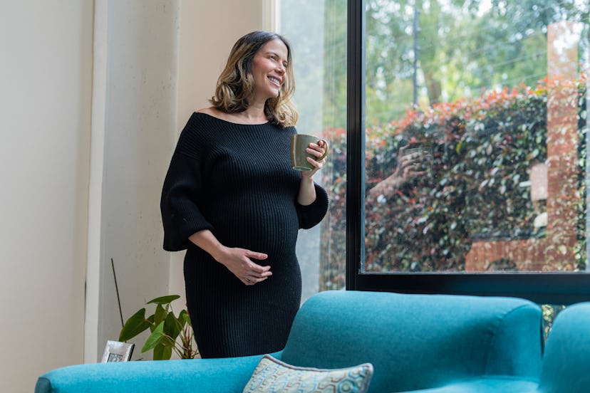 Pregnant millennial woman wearing maternity wear that she rented.