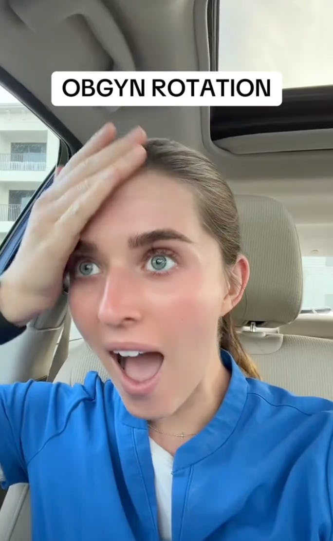 A surprised young woman in a blue medical scrub looks shocked while sitting in a car, touching her forehead, with a caption about "OBGYN ROTATION" above her.