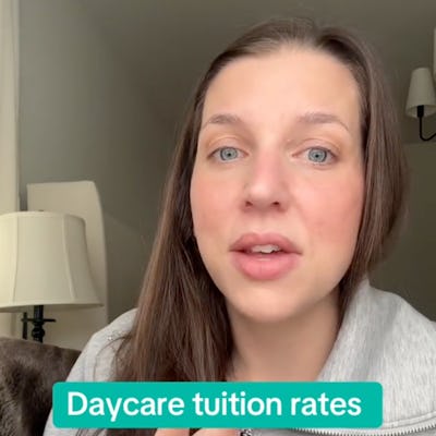 A woman with long brown hair speaks directly to the camera, discussing high daycare tuition rates. A lamp and window are visible in the background.