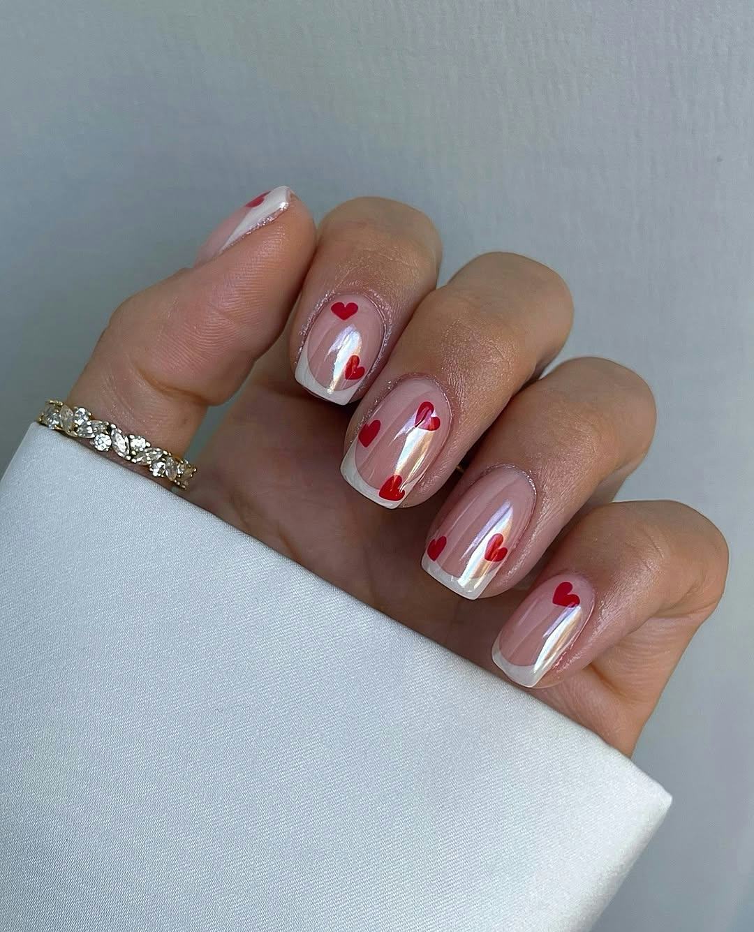 micro-French nails with chrome top coat and heart adornments