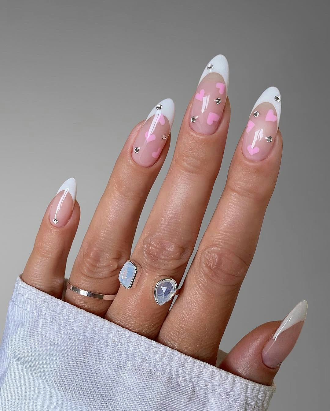 almond-shaped French manicure with pink hearts and crystal nail art