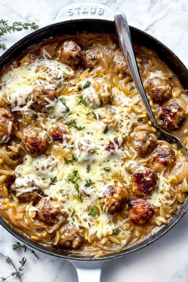 French onion orzo in pan with spoon, a great option for those wanting ground beef recipes that aren'...