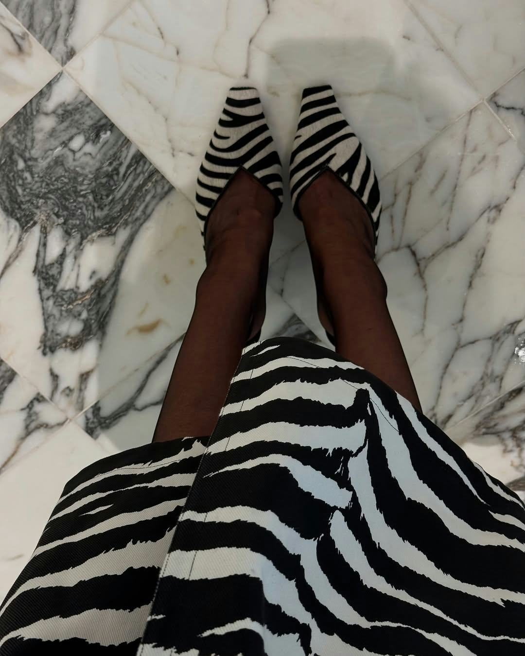 Elsa Hosk wears a zebra print coat and shoes.