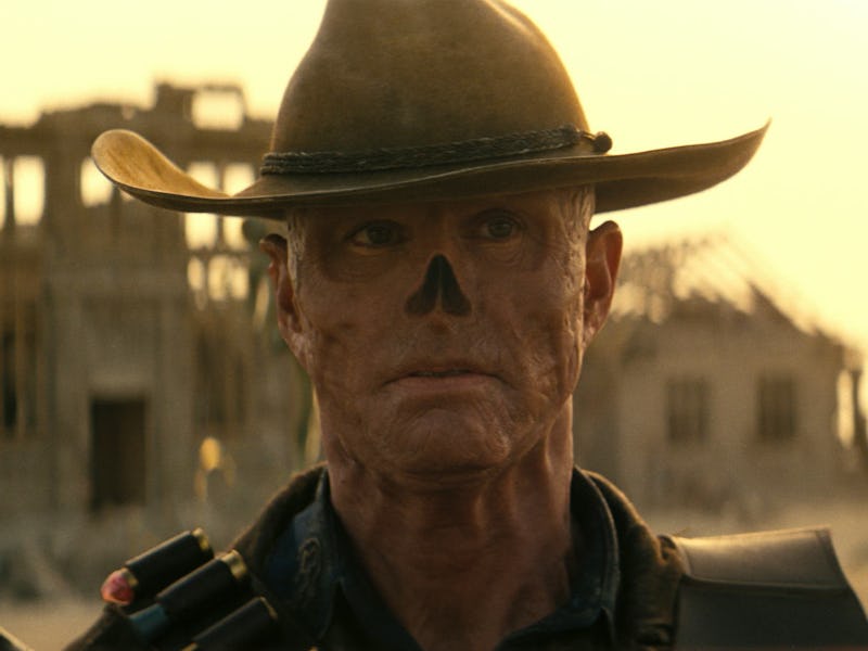 A rugged figure in a wide-brimmed hat stands in a desolate landscape, with a dramatic expression and...