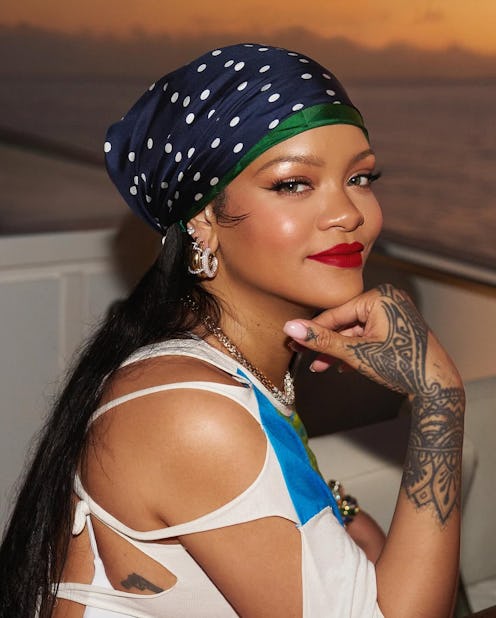 Rihanna wears a white shirt dress with a palm tree print.