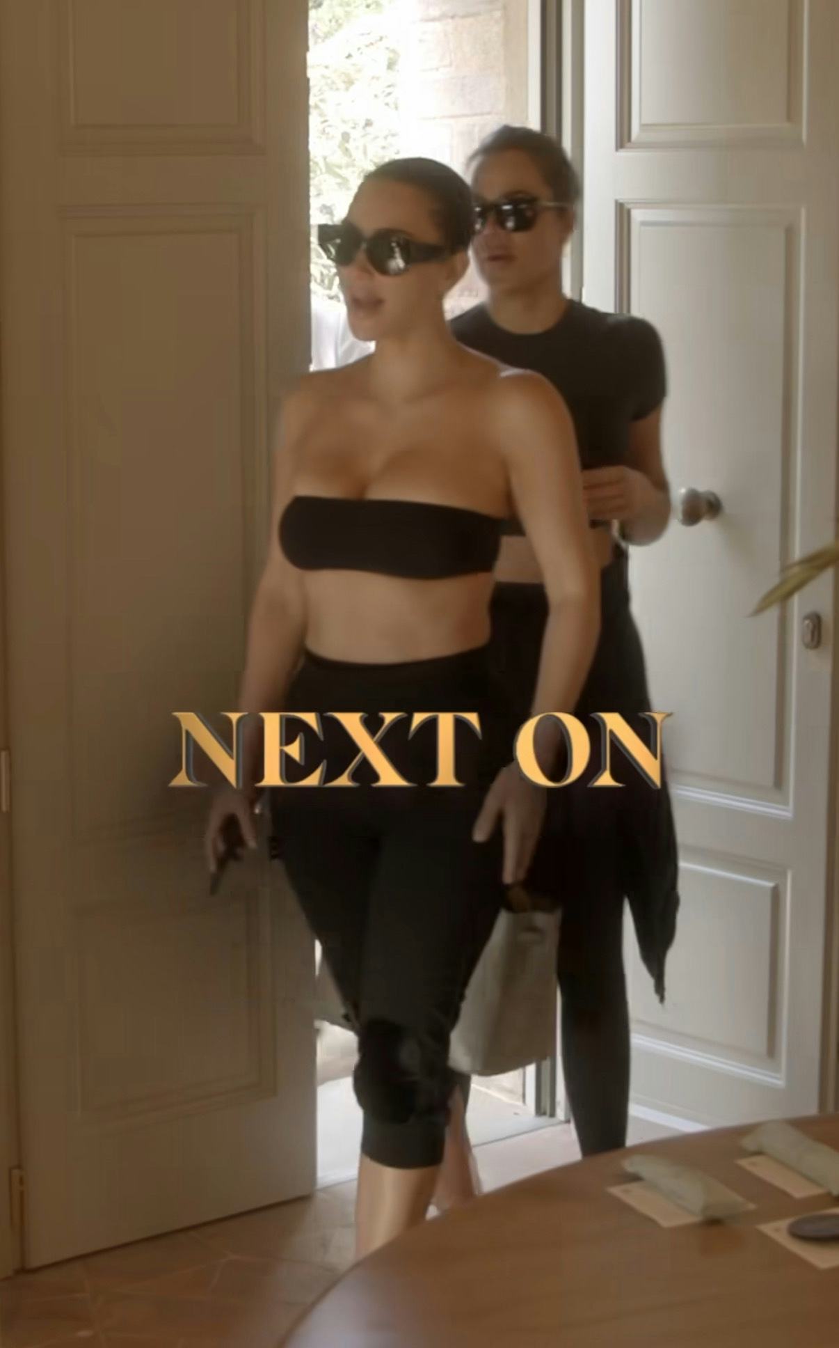 Kim Kardashian wears a bandeau bra and capri pants.