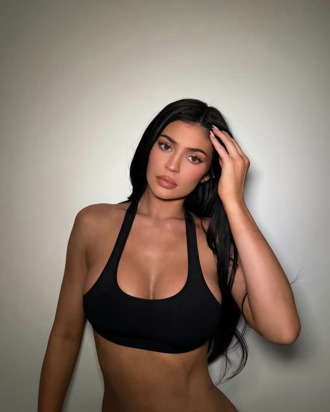 Kylie Jenner wears a sports bra as a top and footed leggings.