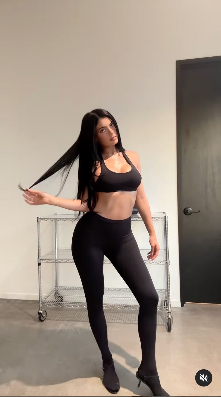 Kylie Jenner wears a bra as a top and footed leggings.