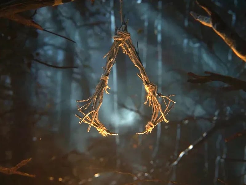 The Assassin's insignia made of twigs hanging from a tree in a forest