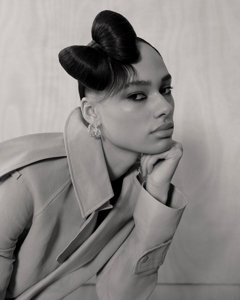 a person with a hello kitty bow fashioned into a hairstyle photographed in black and white with thei...