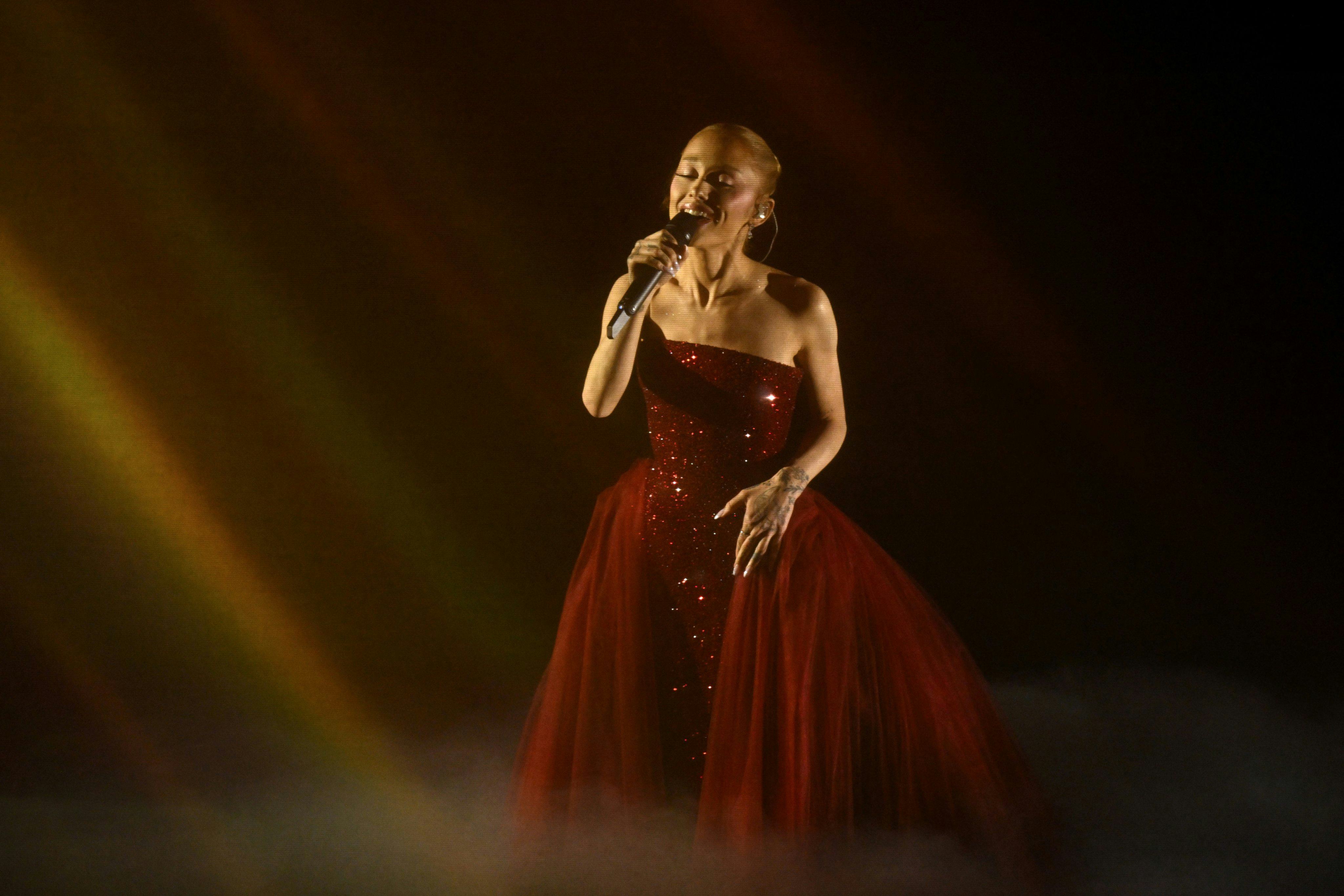 Ariana Grande wears a ruby red dress.