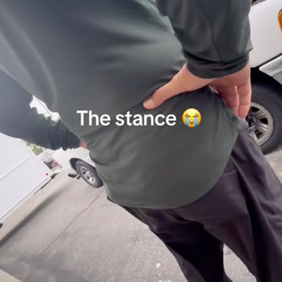 A person stands with their back to the camera, wearing a long-sleeve green shirt and dark pants. Text overlay reads "The stance 😢."