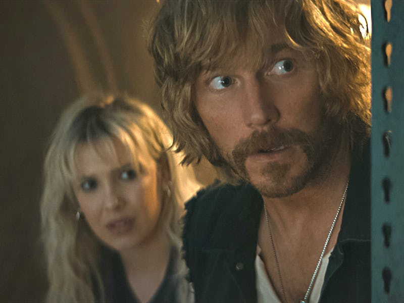 A man with tousled hair and a mustache looks concerned, while a woman beside him appears worried, bo...