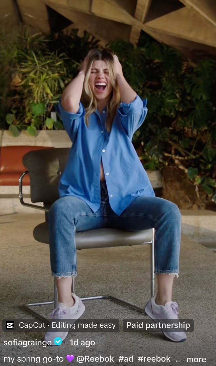 Sofia Richie wears a button-down, jeans, and Reebok sneakers.
