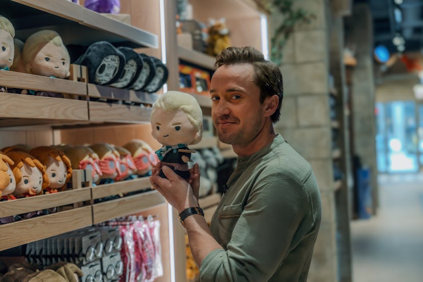 Tom Felton holds a Draco Malfoy plush toy at the Harry Potter Shop in Chicago