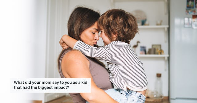 A woman holds her young child, and they smile into each other's faces.