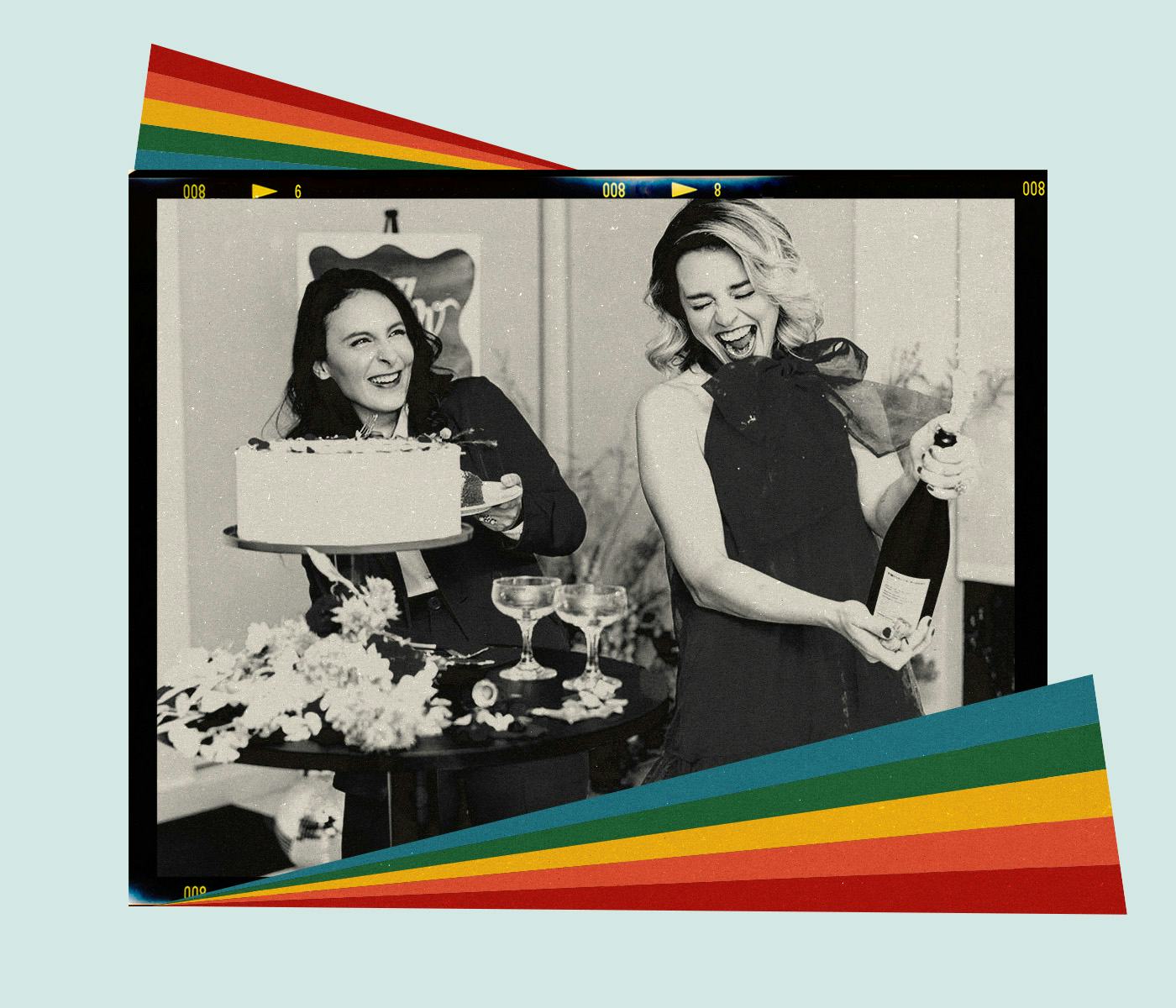 Two women pop champagne during their wedding reception