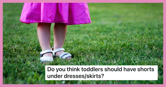 A toddler in a pink dress walks through the grass.