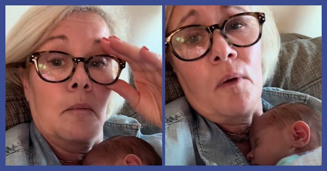 A grandmother looks into the camera while holding a newborn baby.