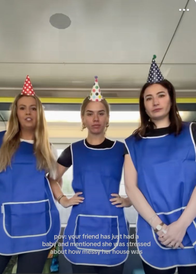 Three women in blue aprons and party hats stand together, smiling playfully. Text below reads about a friend feeling stressed after having a baby.