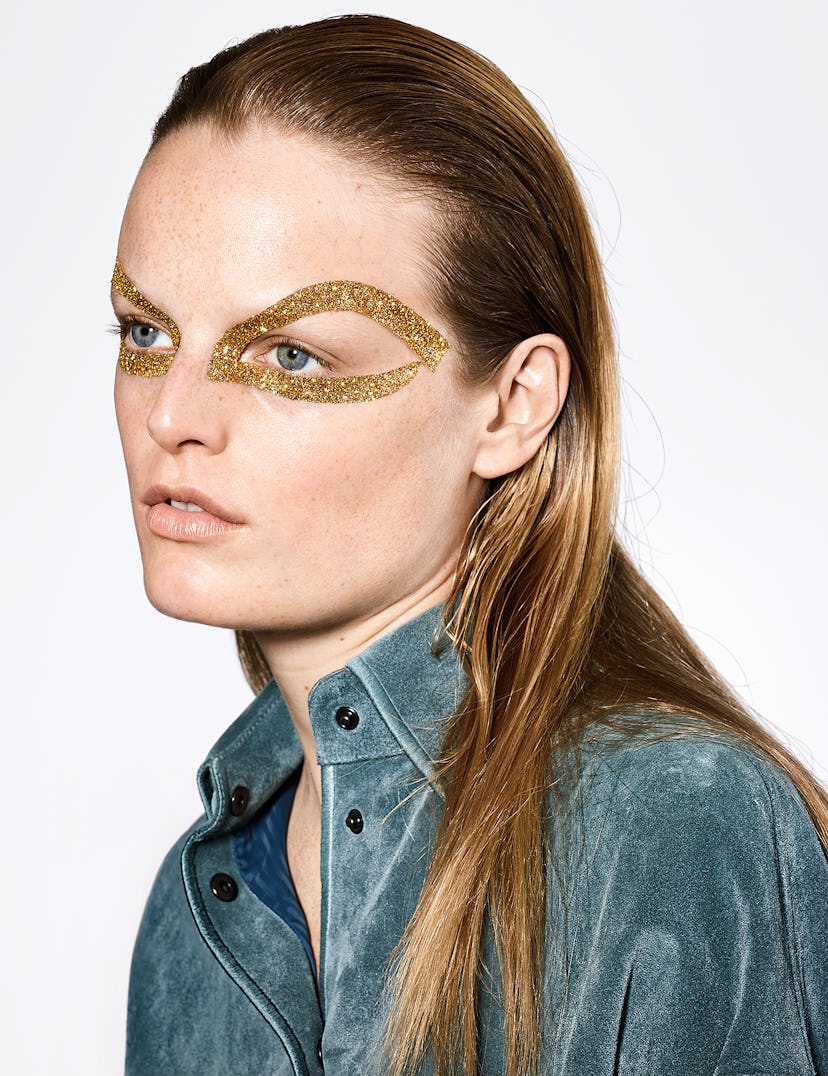 a person with long blonde hair and gold sparkles around their eyes
