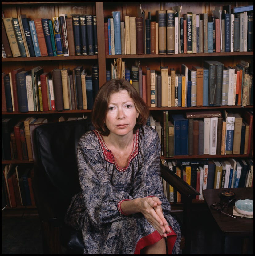 Portrait of American author Joan Didion as she sits in a chair in front of a bookshelf, Berkeley, Ca...