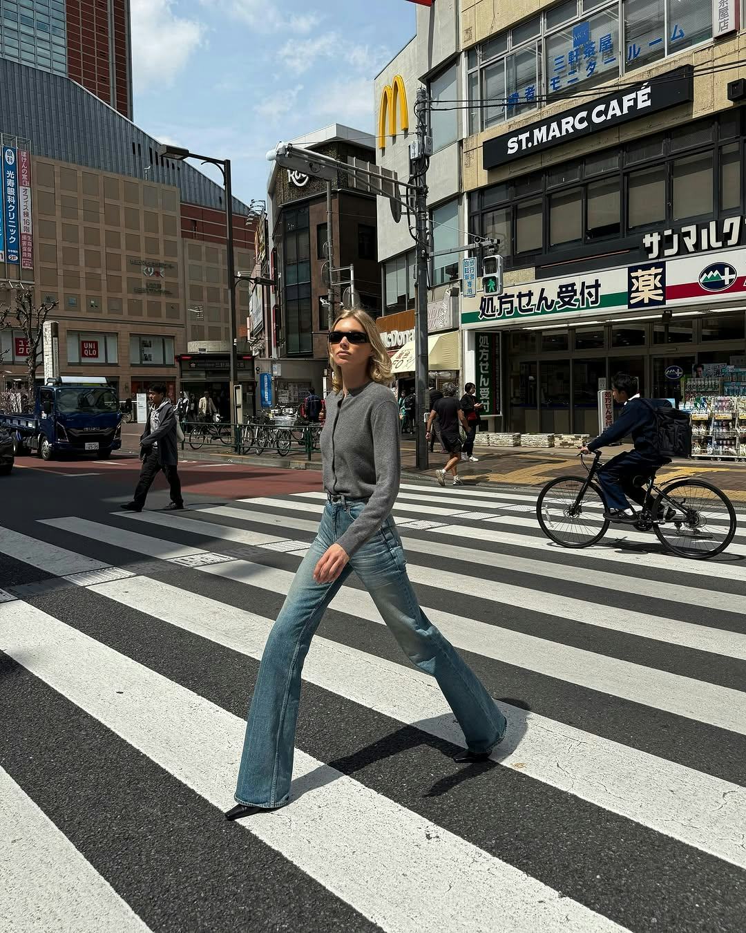 Elsa Hosk wears a gray cardigan and jeans.