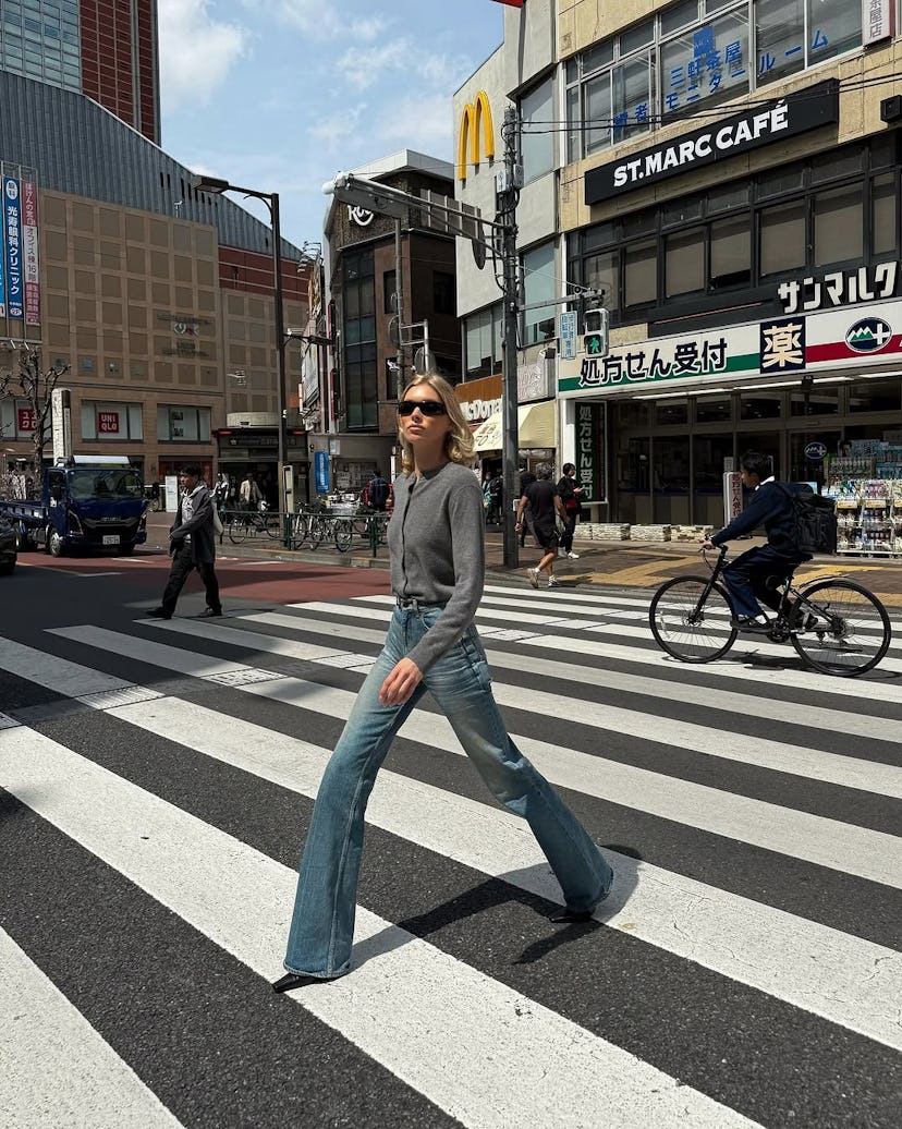 Elsa Hosk wears a gray cardigan and jeans.