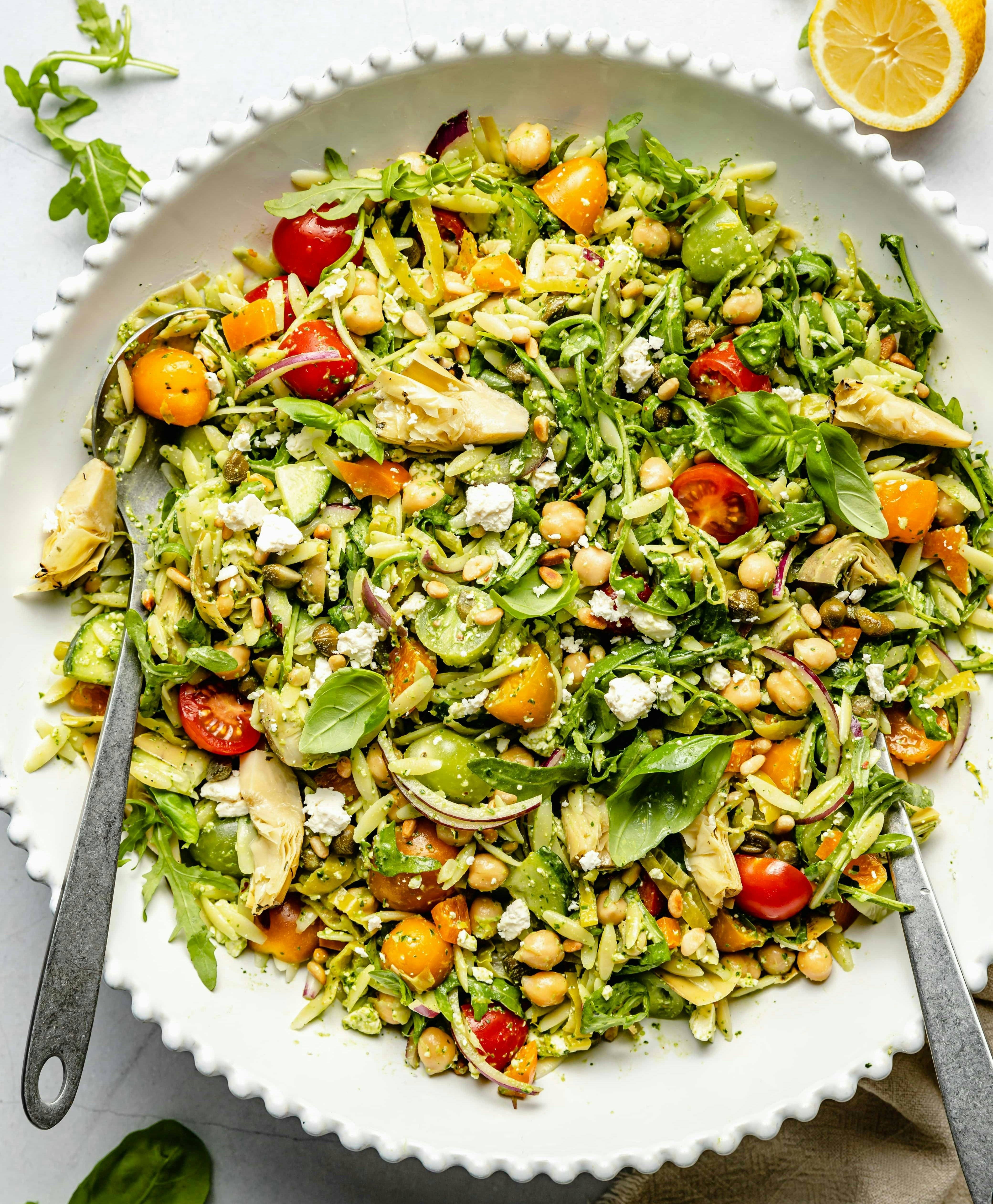 pesto orzo pasta salad in a white bowl, in a story about healthy orzo recipes