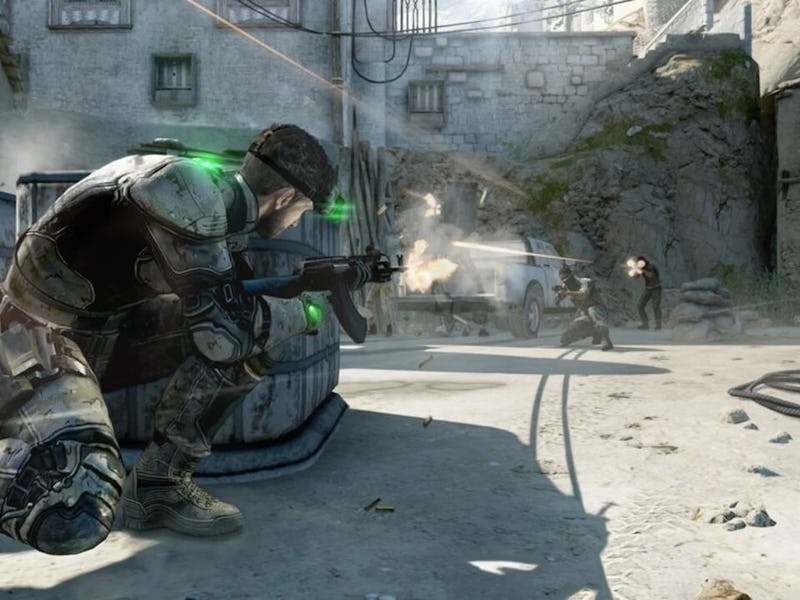 Sam Fisher peaks from behind a chest-high wall