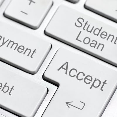 Close-up of a keyboard showing keys labeled "Debt," "Repayment," "Student Loan," and "Accept," highlighting financial themes related to loans.