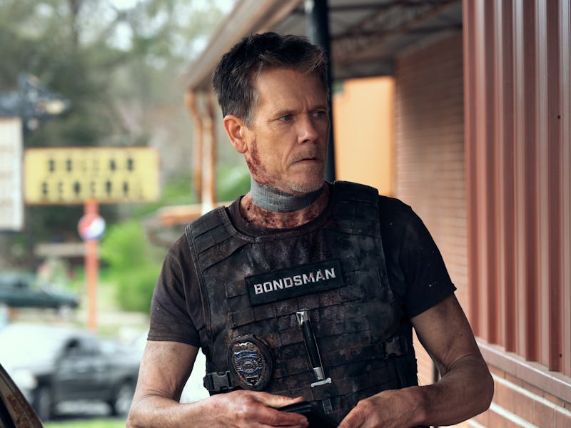 A man wearing a tactical vest labeled "BONDSMAN" stands outside a building, appearing tense. He has ...