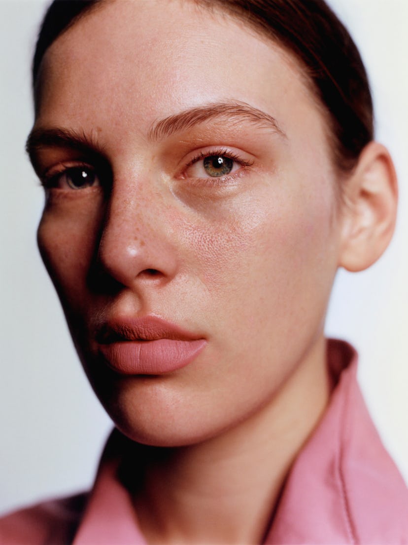 a close up photograph of a person with soft matte pink lipstick on and a pink shirt
