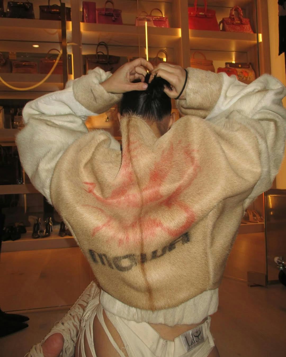 Kim Kardashian wearing a fur coat with assless chaps.