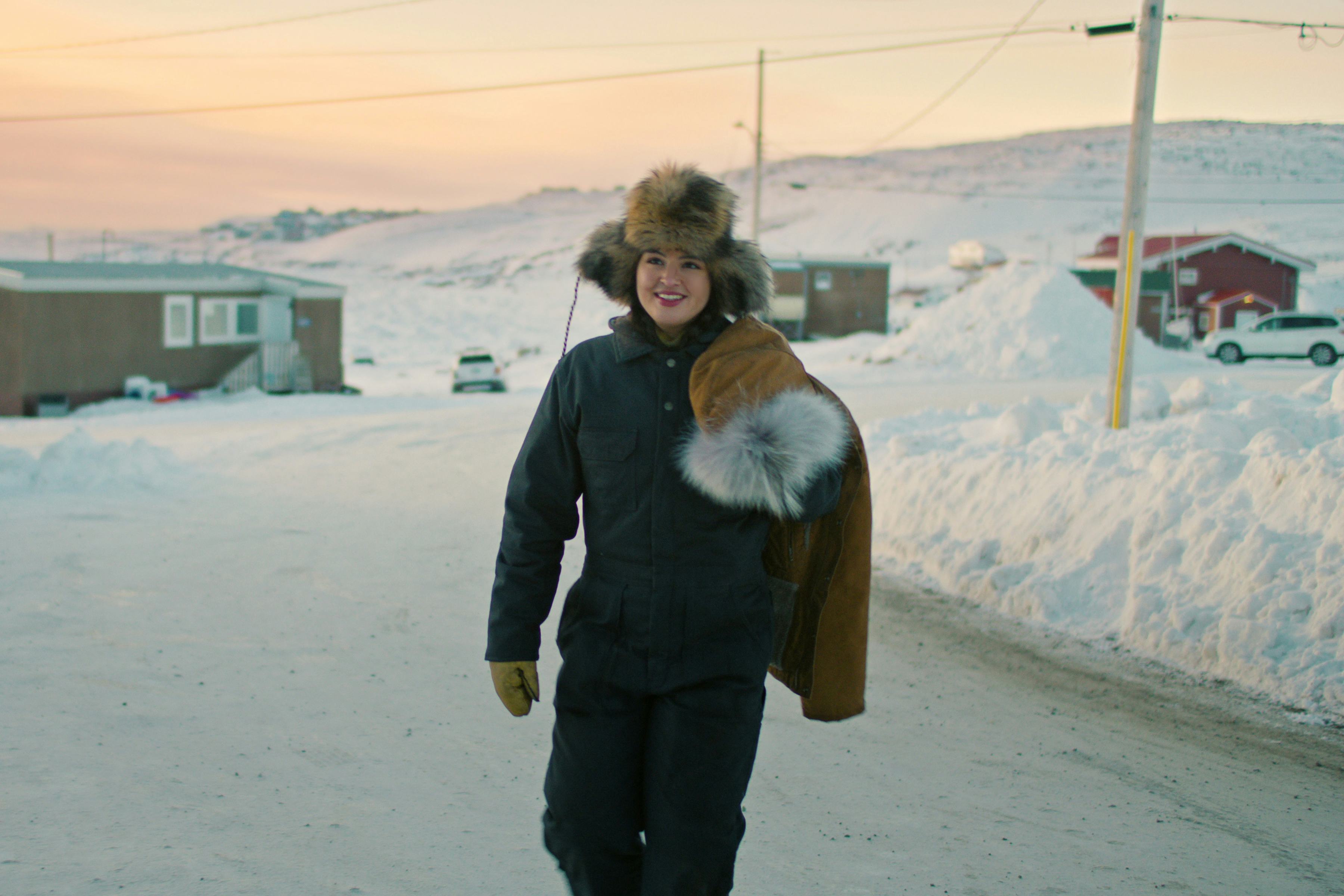 Anna Lambe as Siaja walking outside in her snowy small town in &lsquo;North of North.&rsquo; Photo via Netflix