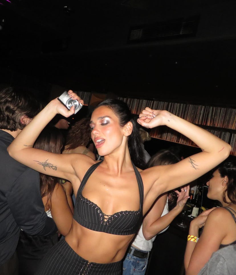 Dua Lipa wore a plunging pinstripe bra and lace-up skirt.